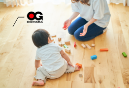 お母さんと赤ちゃんが床の上で遊ぶ写真